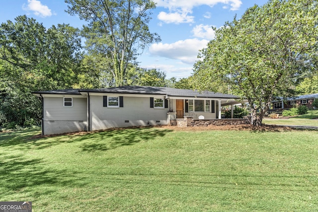 view of front of home with a carport, brick siding, crawl space, and a front yard