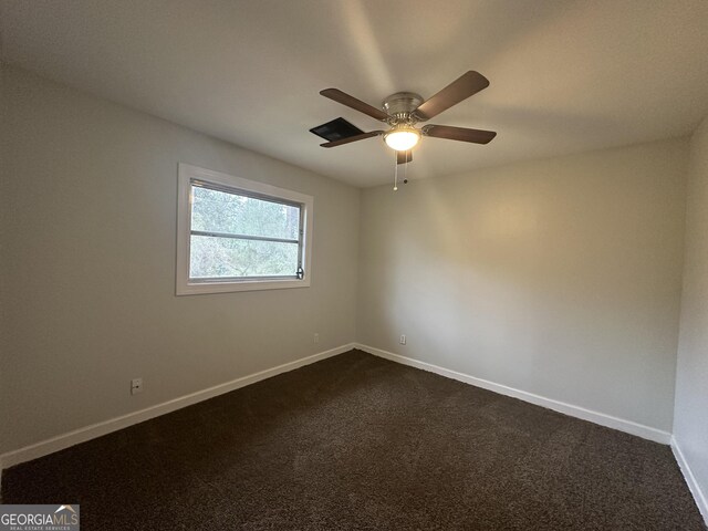 empty room featuring a ceiling fan, baseboards, and dark colored carpet