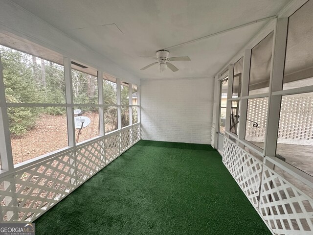 unfurnished sunroom featuring a ceiling fan