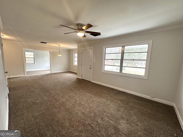 interior space featuring visible vents, crown molding, dark colored carpet, baseboards, and ceiling fan