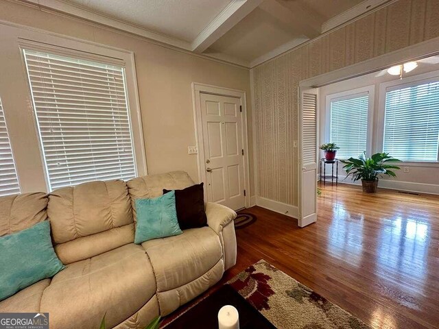 living room with crown molding, hardwood / wood-style floors, and beamed ceiling