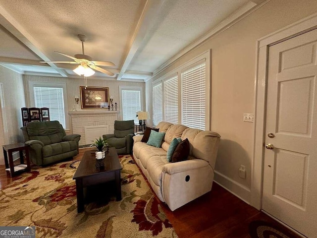 living area featuring baseboards, coffered ceiling, wood finished floors, a textured ceiling, and beam ceiling