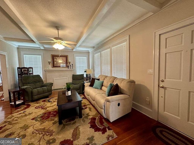 living room featuring ceiling fan, dark wood-type flooring, a textured ceiling, and beamed ceiling