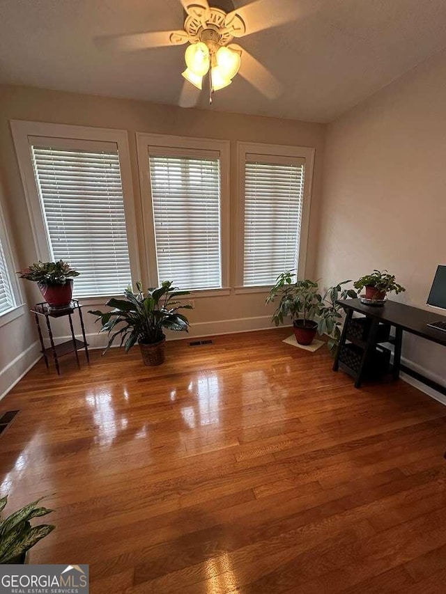 unfurnished room featuring visible vents, ceiling fan, baseboards, and wood finished floors