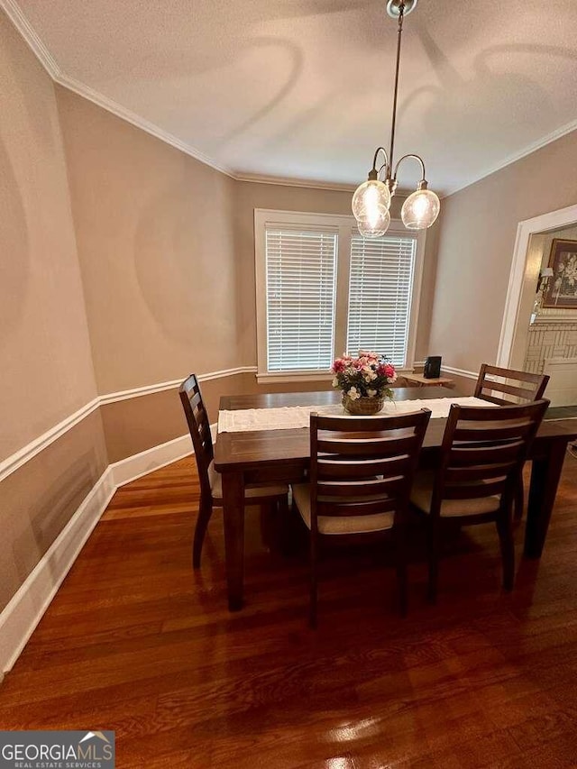 dining space with a textured ceiling, a notable chandelier, baseboards, ornamental molding, and dark wood-style floors