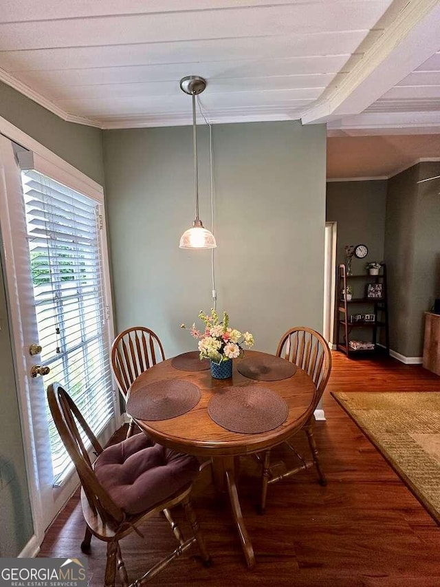 dining area with ornamental molding and dark wood-type flooring