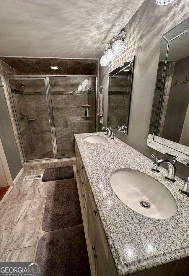 bathroom featuring tile patterned floors, a shower with door, and vanity