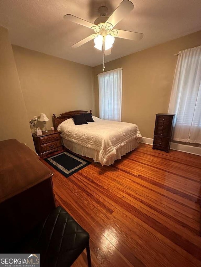 bedroom with baseboards, a ceiling fan, and wood finished floors