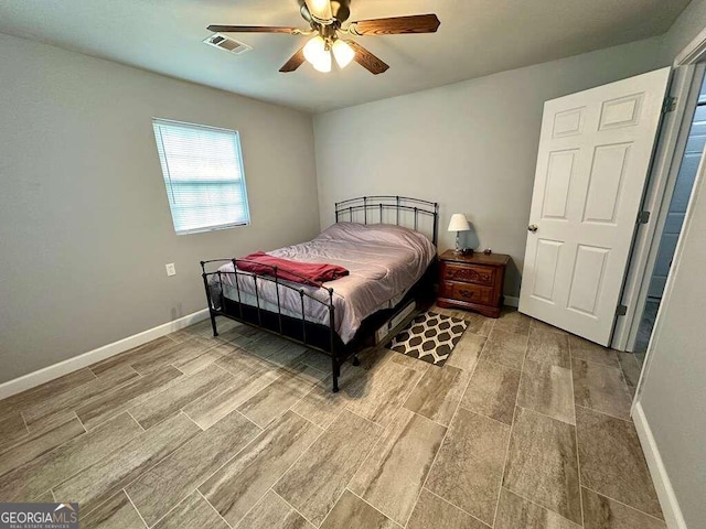 bedroom featuring a ceiling fan, wood tiled floor, visible vents, and baseboards