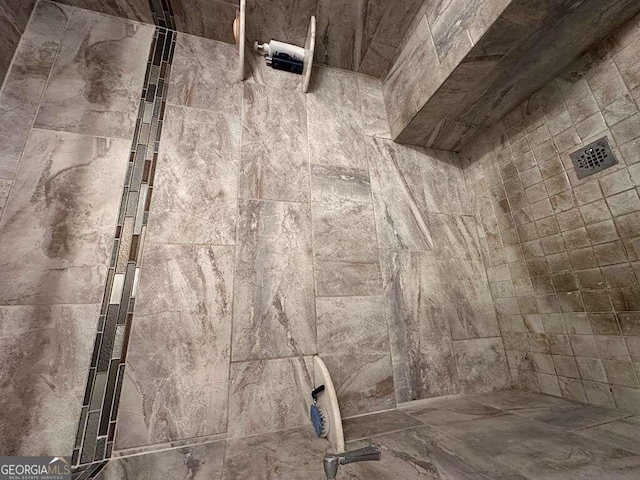 interior details featuring a tile shower