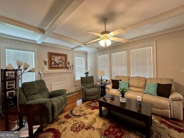 living area with beamed ceiling, coffered ceiling, wood finished floors, and a healthy amount of sunlight