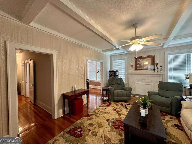 living area featuring dark wood-type flooring, beam ceiling, and a textured ceiling