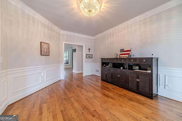 interior space featuring crown molding, light hardwood / wood-style flooring, and a chandelier