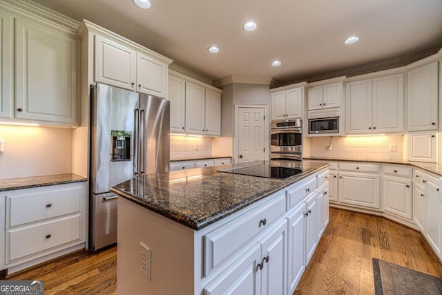 kitchen featuring white cabinetry, wood-type flooring, tasteful backsplash, and stainless steel appliances