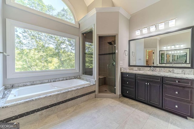 bathroom with shower with separate bathtub, vanity, a towering ceiling, and tile patterned floors