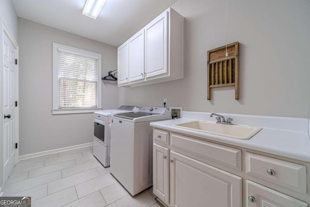 laundry area with sink, washing machine and clothes dryer, light tile patterned floors, and cabinets