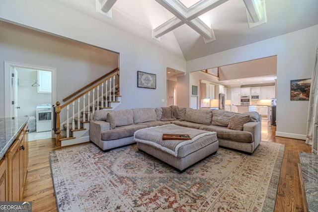 living room featuring high vaulted ceiling and light wood-type flooring