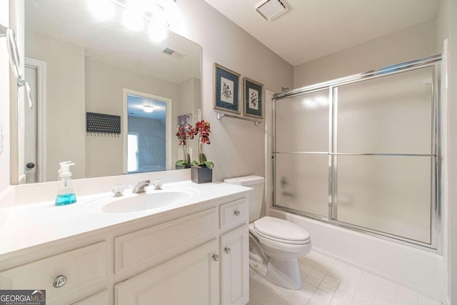 full bathroom featuring tile patterned floors, toilet, vanity, and combined bath / shower with glass door