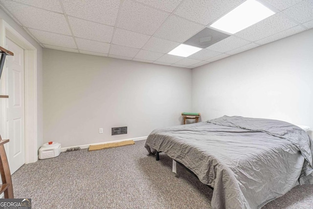 carpeted bedroom with a drop ceiling