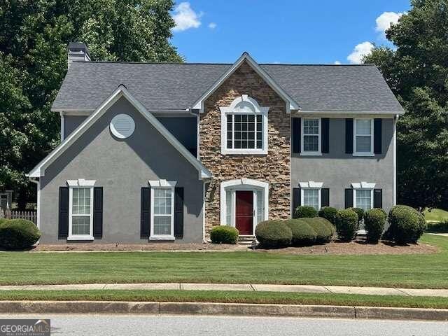 colonial house featuring a front lawn