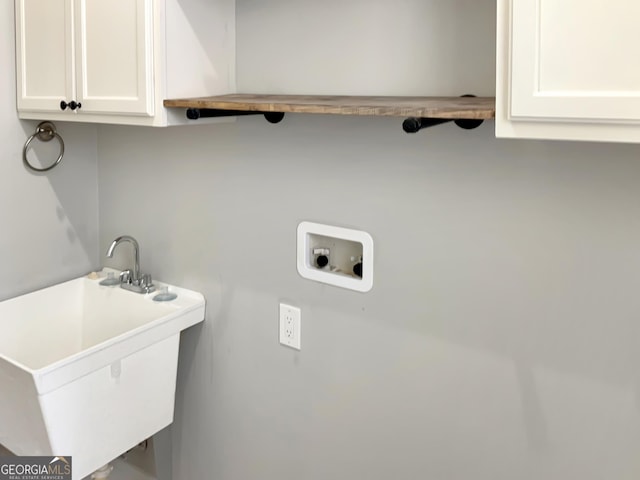 laundry room with a sink, hookup for a washing machine, and cabinet space