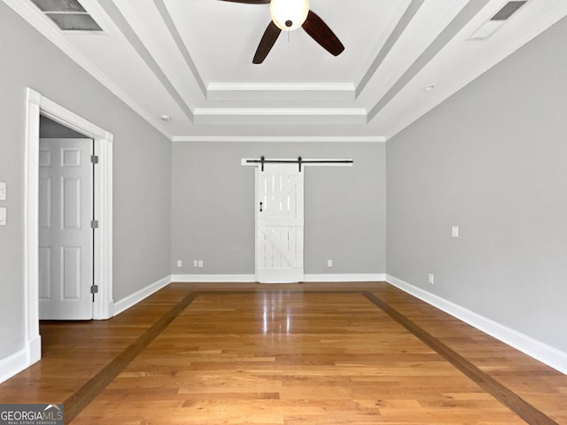 305 Crest Pointe S, Bremen, GA 30110 - empty room featuring a tray ceiling, a barn door, a ceiling fan, light wood-style flooring, and ornamental molding