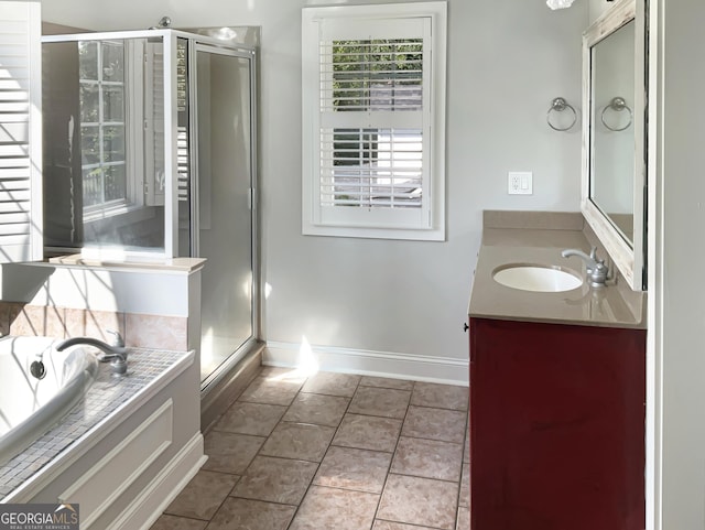 bathroom featuring a garden tub, vanity, baseboards, tile patterned floors, and a stall shower