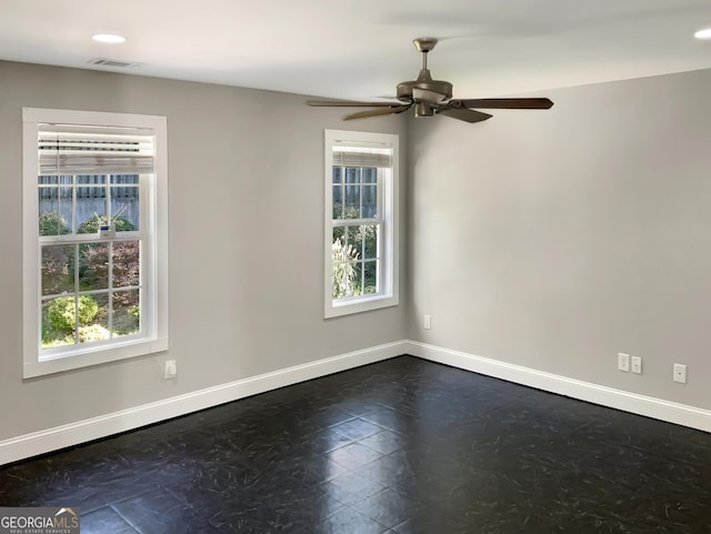 empty room with a ceiling fan, a healthy amount of sunlight, visible vents, and baseboards