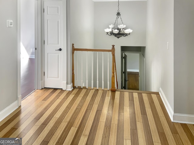 interior space featuring baseboards, an inviting chandelier, and wood finished floors