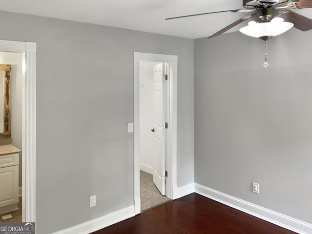 unfurnished bedroom with dark wood finished floors, a ceiling fan, and baseboards