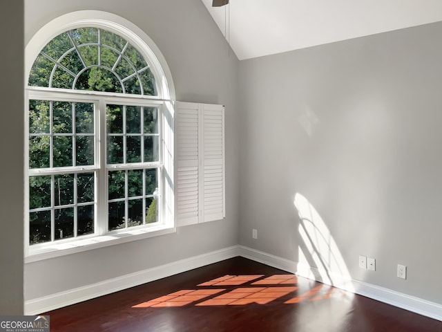 unfurnished room with lofted ceiling, baseboards, and wood finished floors