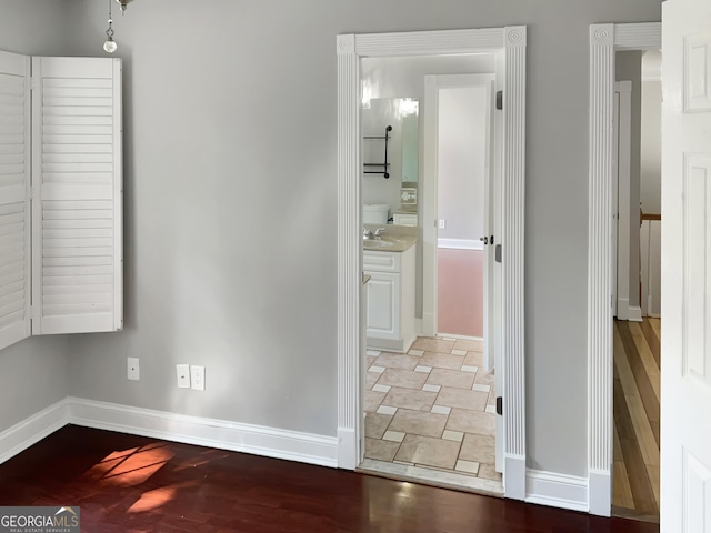 interior space featuring a sink, baseboards, and wood finished floors