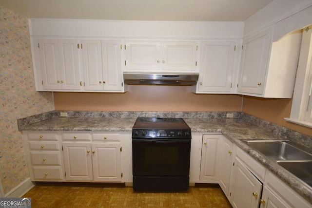 kitchen featuring sink, light stone counters, white cabinets, and black range oven