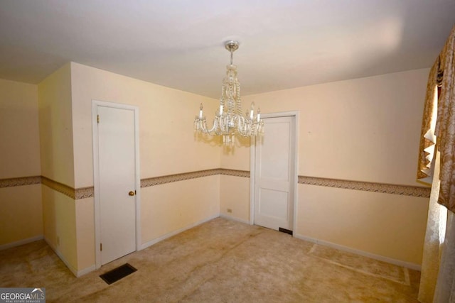 unfurnished dining area featuring a chandelier and light colored carpet