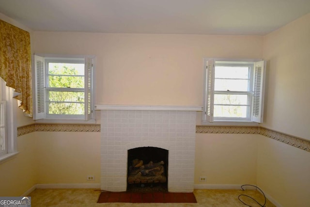 unfurnished living room with a fireplace, carpet flooring, and a healthy amount of sunlight