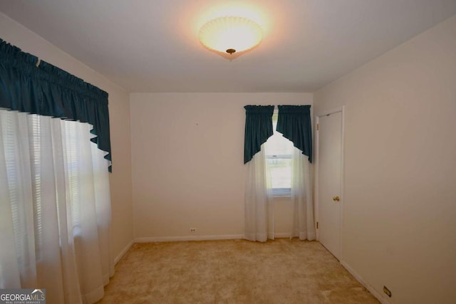 spare room featuring light colored carpet