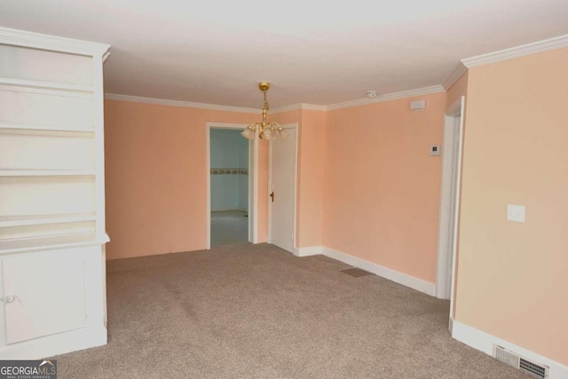 carpeted spare room with a notable chandelier and ornamental molding