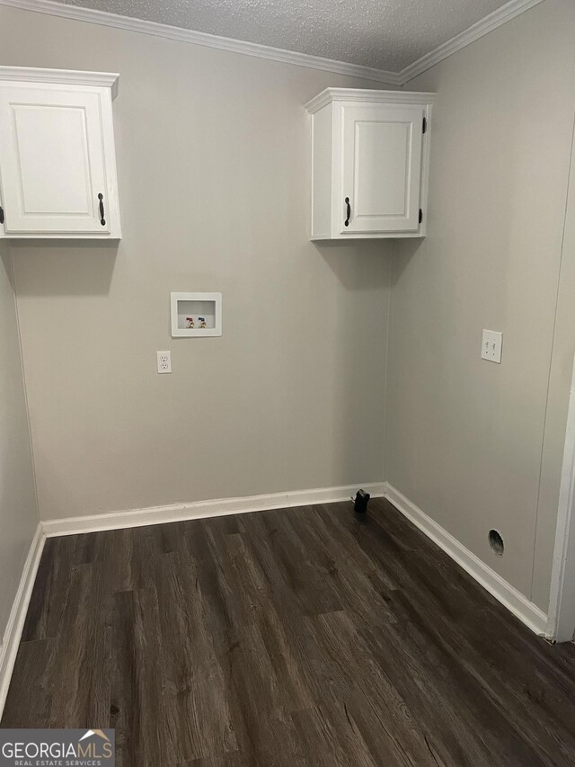 washroom featuring washer hookup, crown molding, dark hardwood / wood-style floors, and cabinets