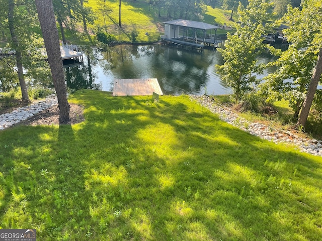 view of yard featuring a water view and a boat dock