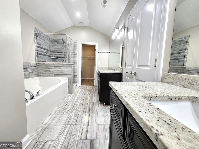 bathroom with lofted ceiling, separate shower and tub, and vanity