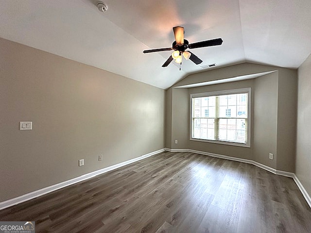 empty room featuring ceiling fan, lofted ceiling, and dark wood-type flooring