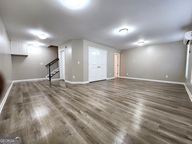 basement featuring hardwood / wood-style flooring and a wall mounted AC