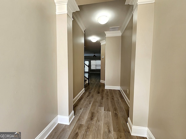 hallway featuring ornate columns, hardwood / wood-style flooring, and ornamental molding