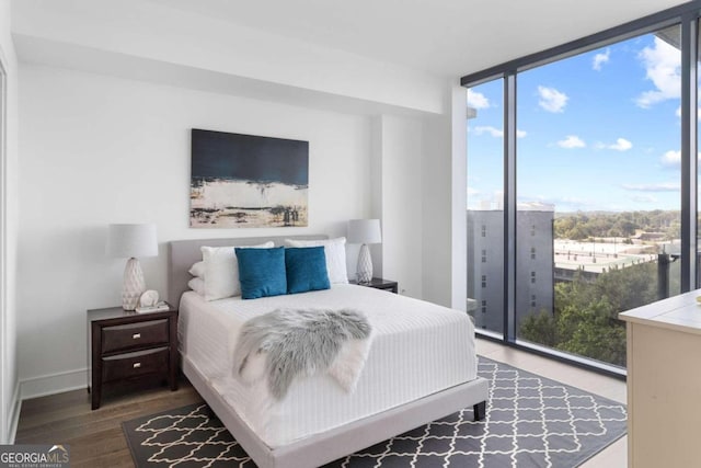 bedroom with expansive windows and wood-type flooring