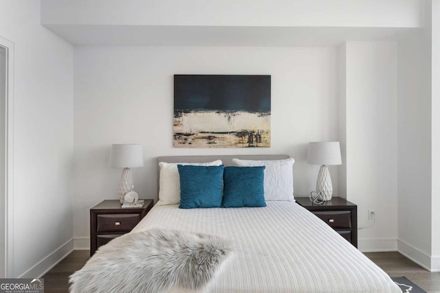 bedroom featuring baseboards and dark wood-type flooring