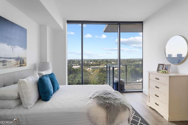 bedroom featuring access to outside, light hardwood / wood-style flooring, and floor to ceiling windows