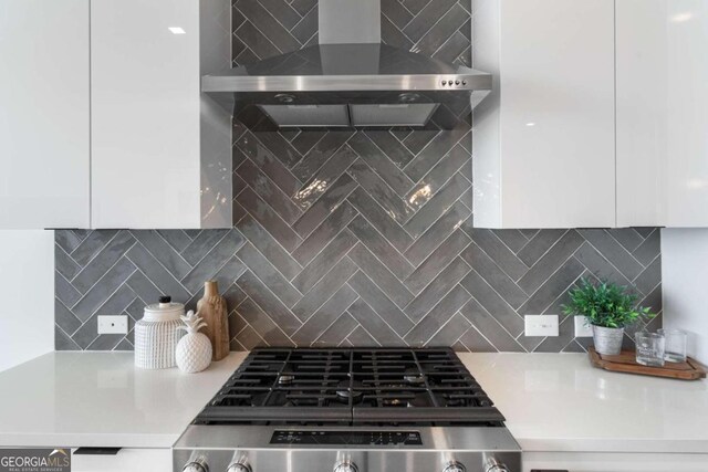 kitchen with white cabinets, tasteful backsplash, and wall chimney range hood