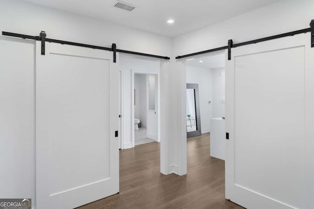 interior space featuring a barn door and wood-type flooring