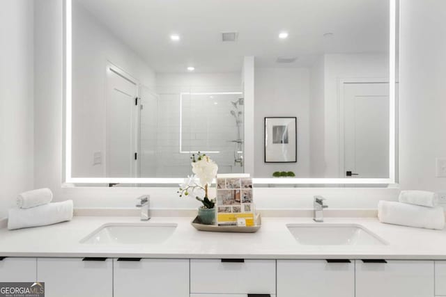 bathroom featuring double vanity, a sink, and a shower stall