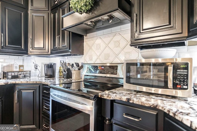 kitchen featuring custom range hood, backsplash, appliances with stainless steel finishes, and light stone countertops